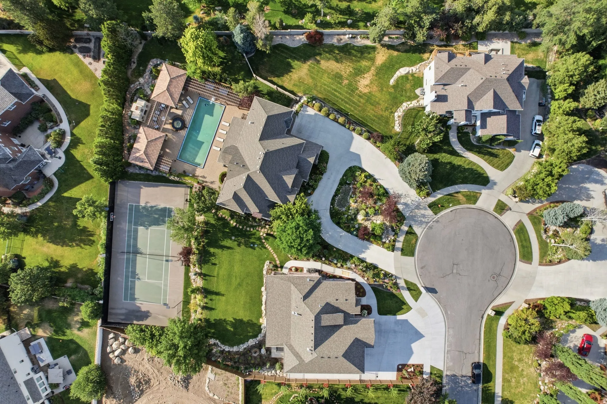 Expansive property featuring a tennis court, swimming pool, and multiple detached structures