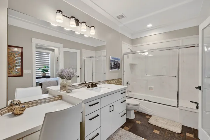 White vanity with integrated sink, black hardware, and quartz countertop