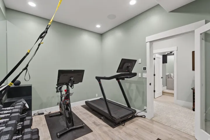 Recessed lighting illuminates the room with wood-finish flooring