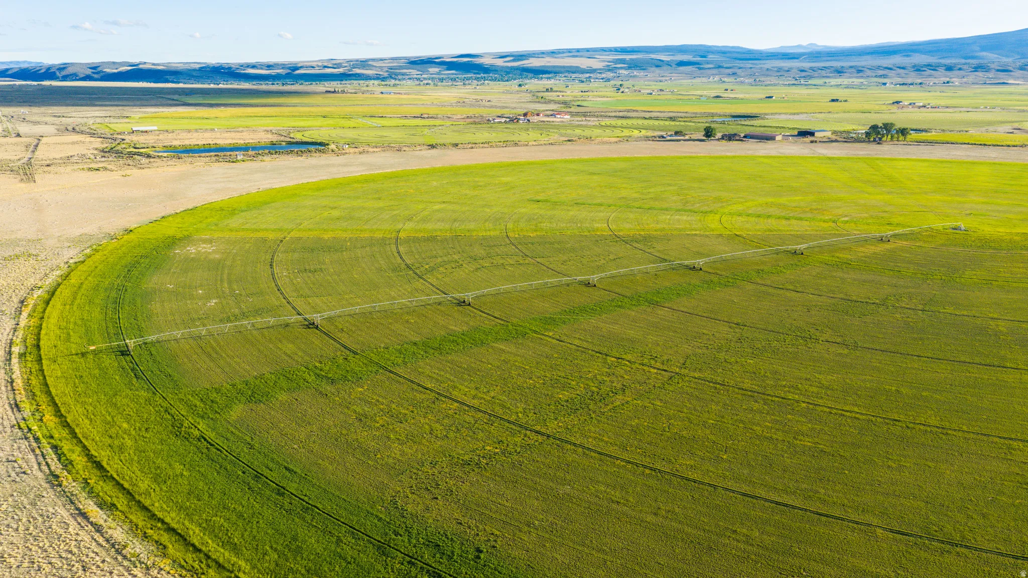 Expansive agricultural land featuring a central pivot irrigation system