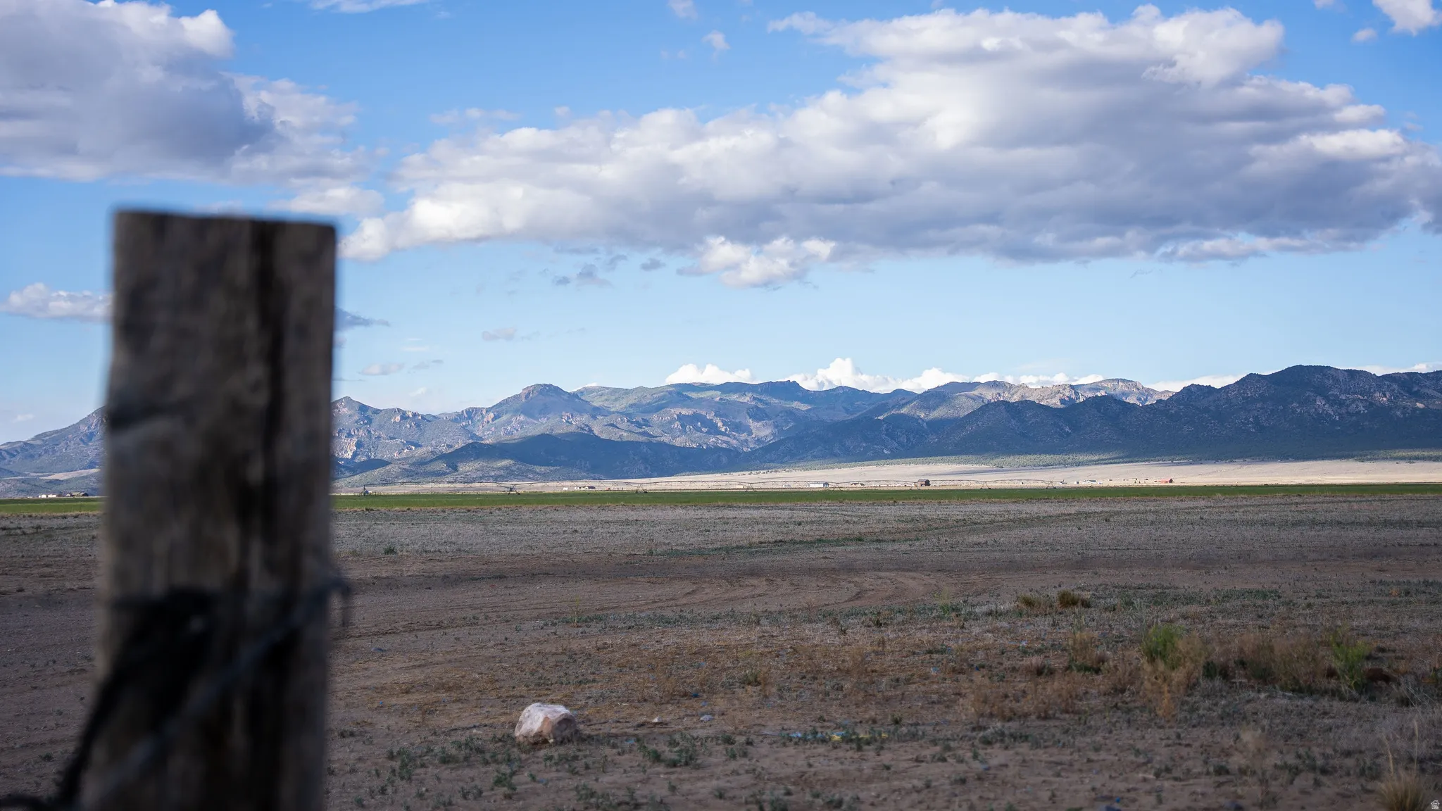 Expansive open land with distant mountain ranges and a clear sky