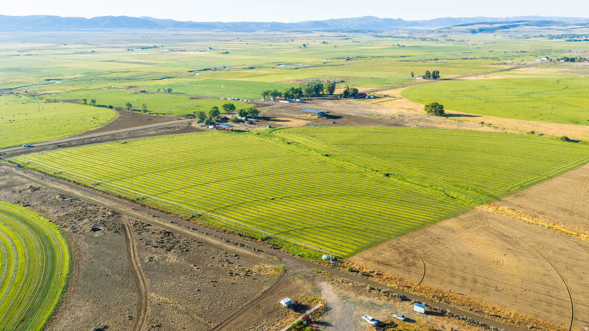 Expansive agricultural landscape featuring cultivated fields and distant mountainous terrain