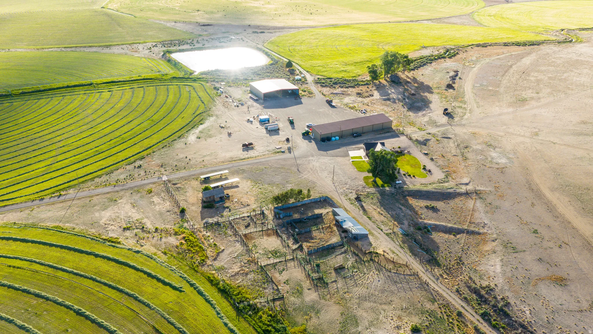 Expansive agricultural property featuring cultivated fields and a large pond