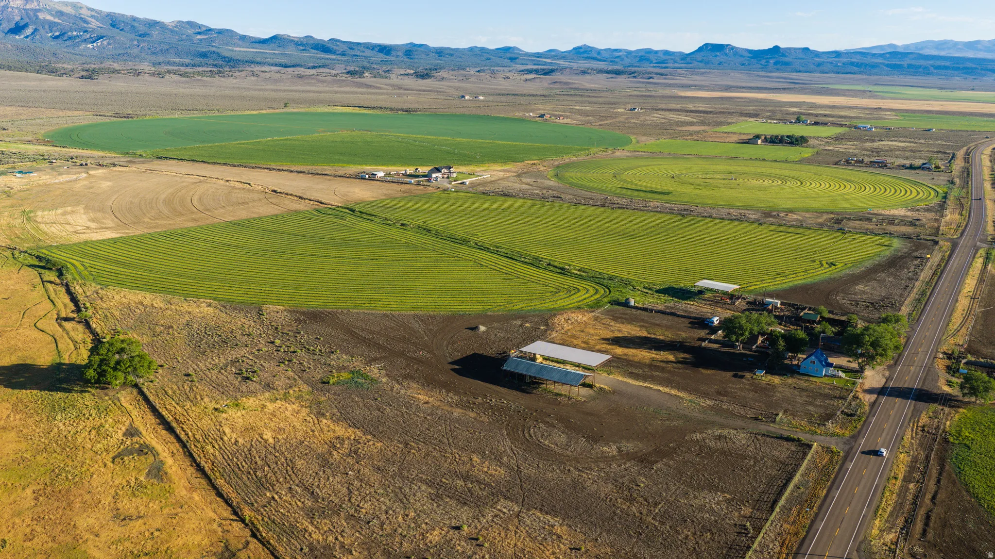 Expansive agricultural property featuring cultivated fields and a paved highway access