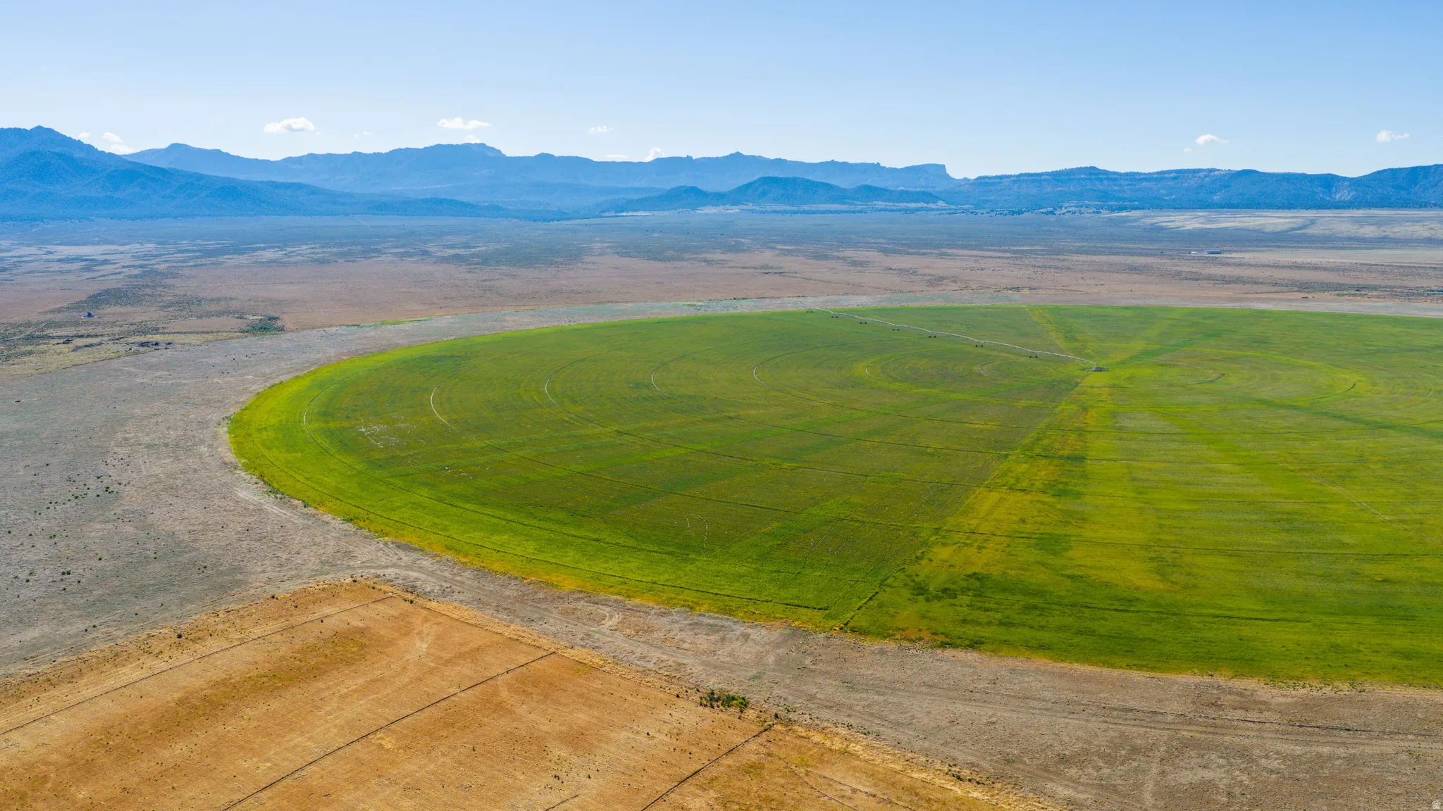 Expansive agricultural land featuring a central pivot irrigation system