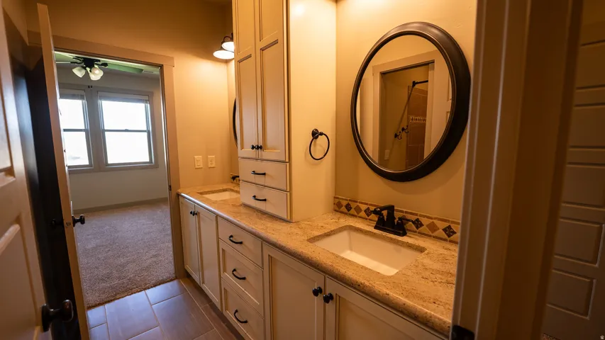 Dual vanity with integrated sinks, granite-style countertop, and wood-finish cabinetry