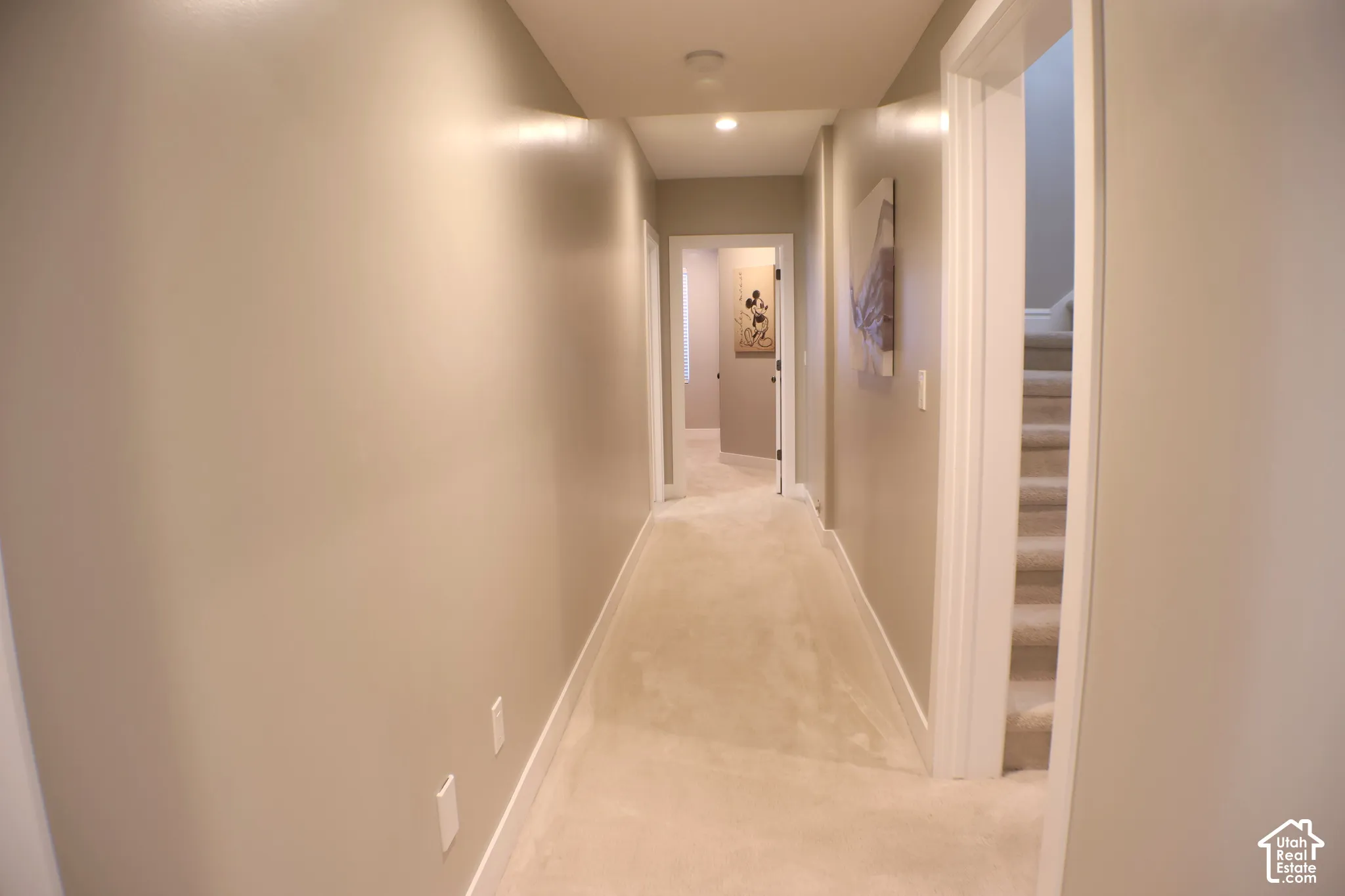 Hallway featuring recessed lighting, light-toned carpeting, and a staircase with carpeted treads