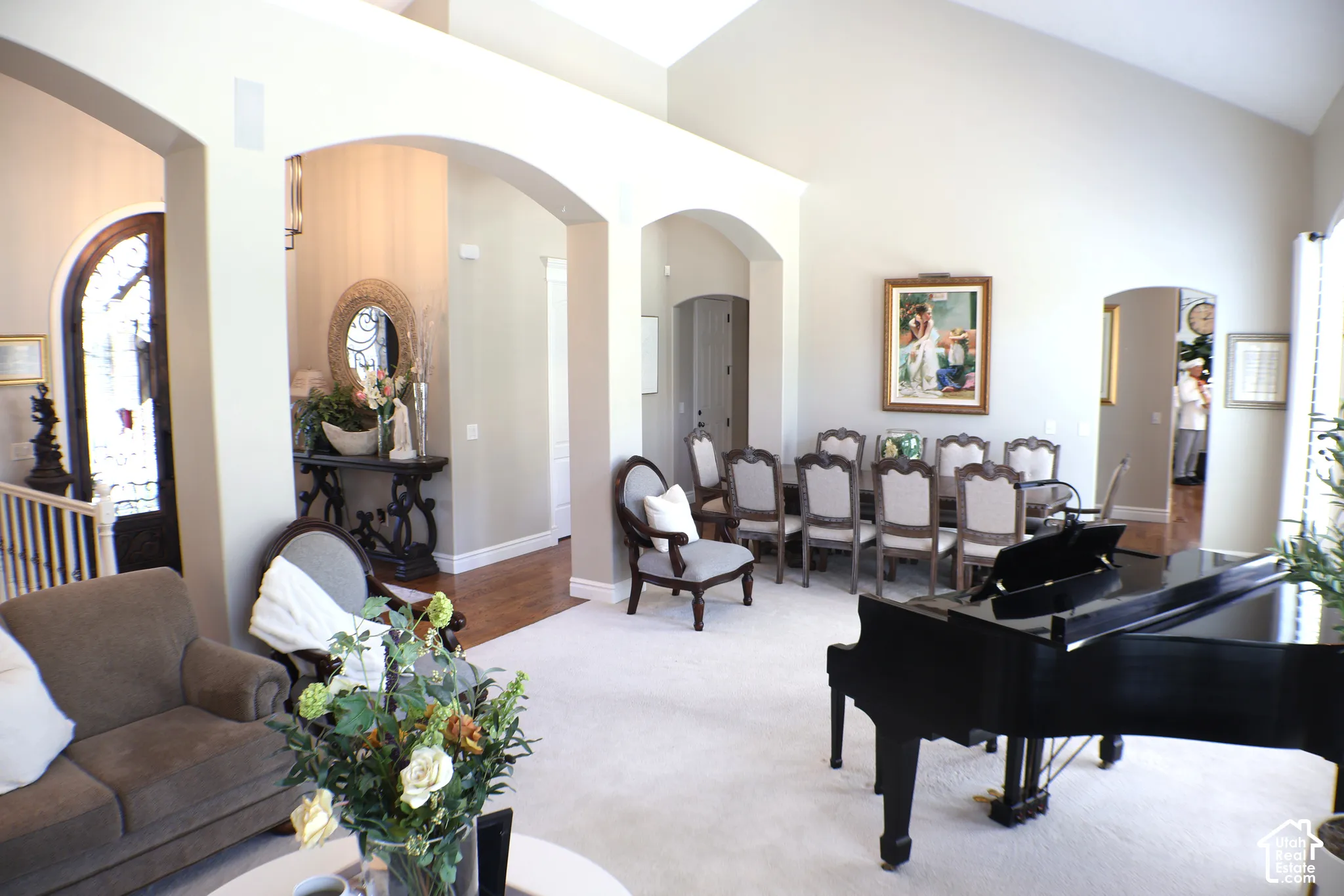 Vaulted ceilings, arched doorways, hardwood flooring, and a formal dining area