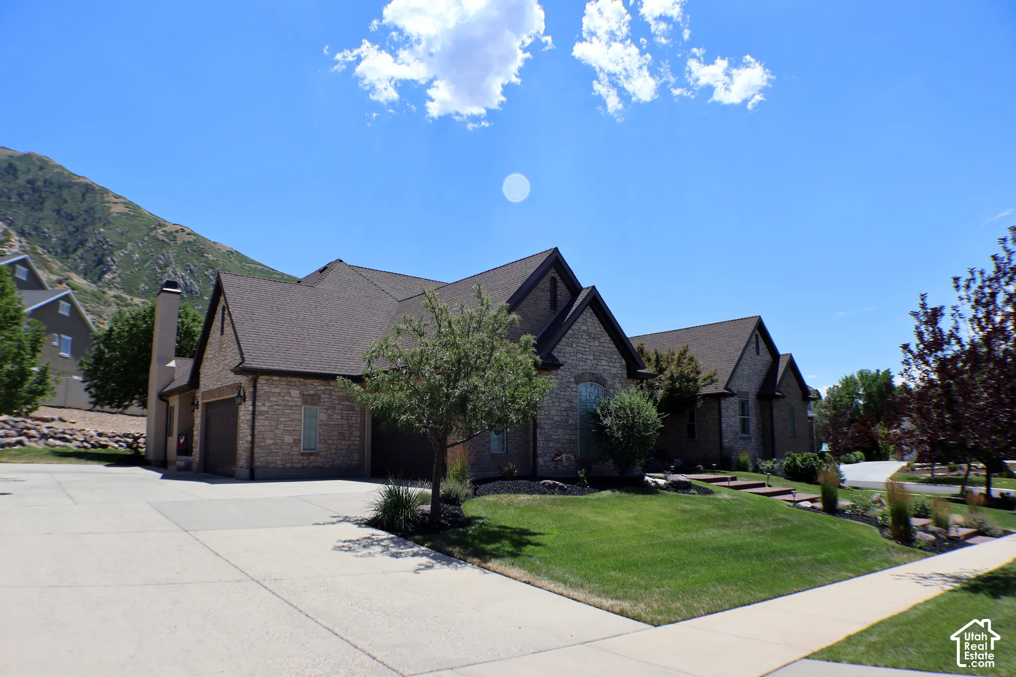 Stone and brick exterior with dark shingle roofing