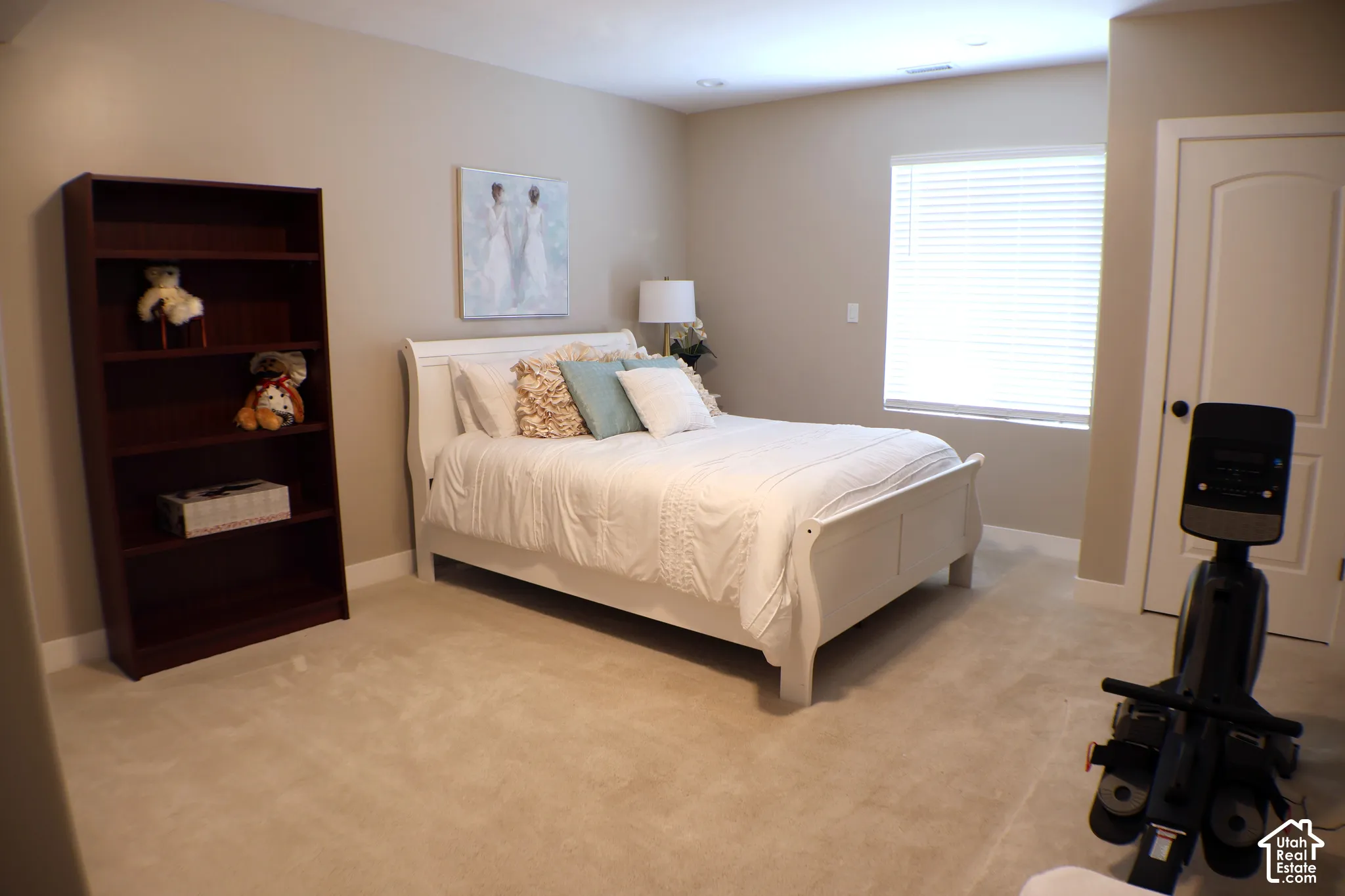 Recessed ceiling lighting, light-colored carpeting, window with blinds, light-toned wall paint, and a classic-style interior door