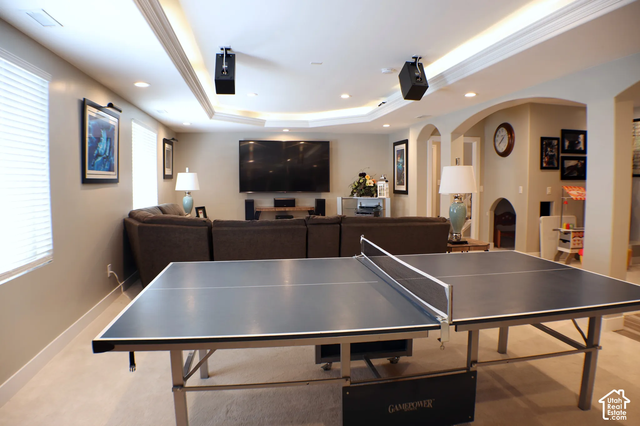 Recessed lighting, arched doorways, tray ceiling, wall sconces, and carpeting throughout