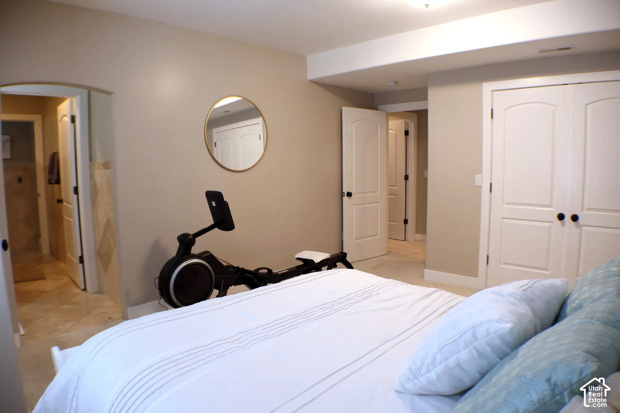 Neutral-toned walls, white trim, recessed ceiling lighting, arched doorways, and built-in double closet doors