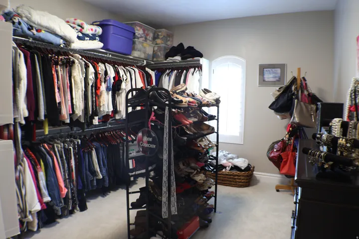 Built-in closet organization system with multiple hanging rods and shelving