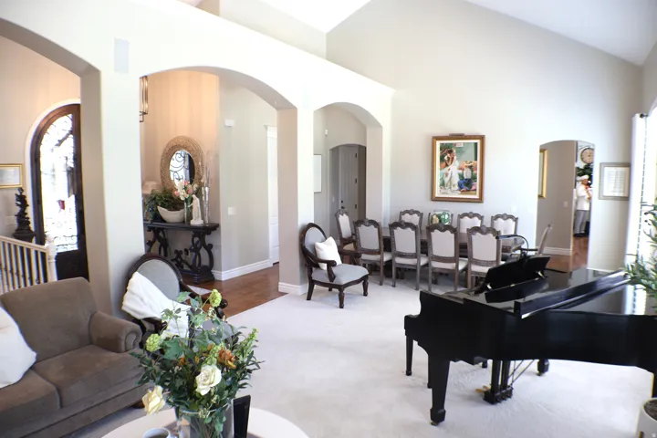 Vaulted ceilings, arched doorways, hardwood flooring, and a formal dining area