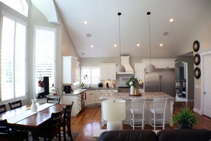 Spacious kitchen featuring white cabinetry, a large center island with seating, stainless steel appliances, and recessed lighting