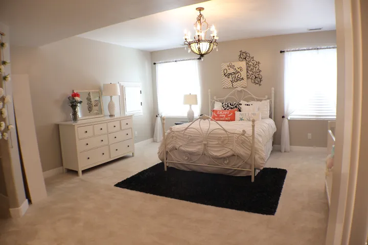 Bright room featuring two windows, neutral wall tones, and a decorative chandelier