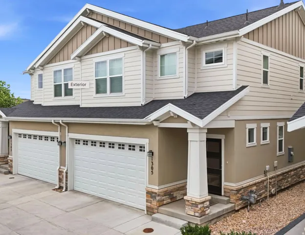 Multi-level exterior with a mixed material facade featuring stucco, siding, and stone accents