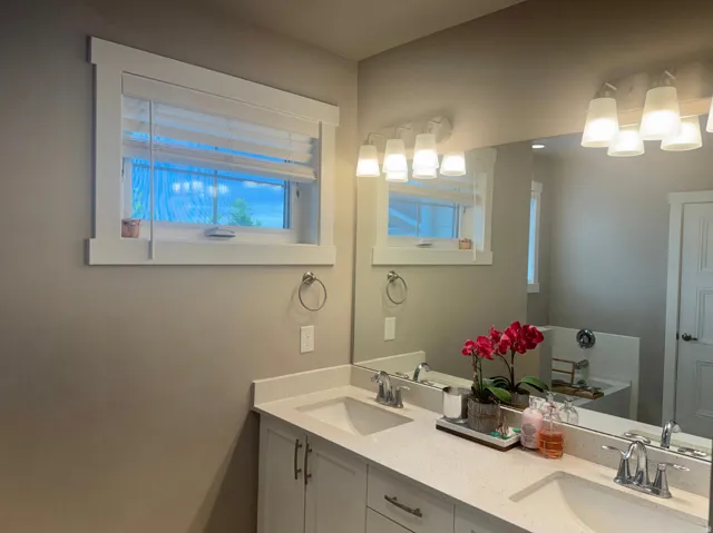 Dual vanity with white cabinetry and light-colored countertops