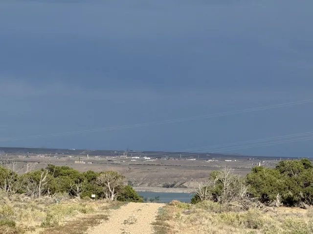 Expansive terrain featuring natural vegetation, a visible body of water, and a distant horizon