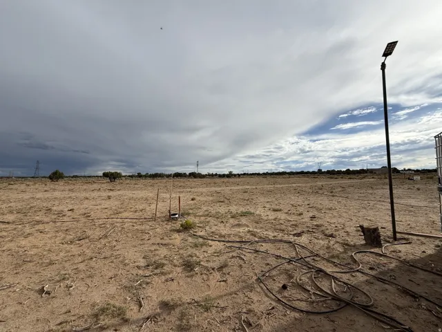 Expansive undeveloped land featuring a solar-powered street light, open terrain, and distant natural growth