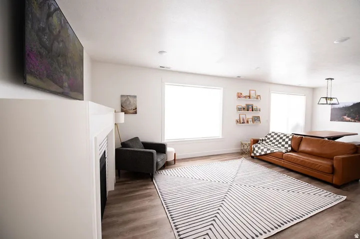 Open-concept living space featuring wood-finish flooring, a built-in fireplace, and recessed lighting