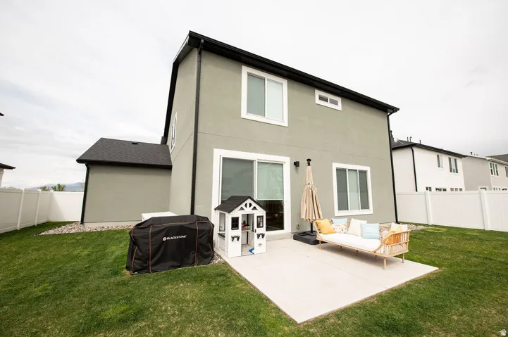 Expansive green lawn, private concrete patio, and a durable white vinyl fence