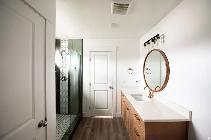 Modern vanity with a single basin, light-toned countertop, and wood-finish cabinetry