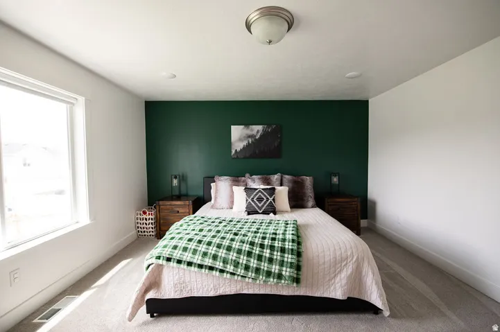 Spacious room featuring a large window, recessed lighting, and a neutral carpeted floor