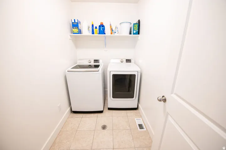 Utility area featuring tiled flooring and a wall-mounted shelf