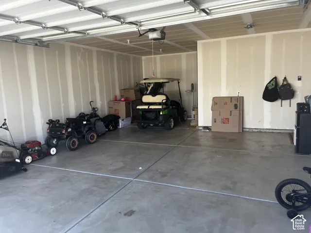 Concrete flooring, unfinished walls, and a visible garage door mechanism