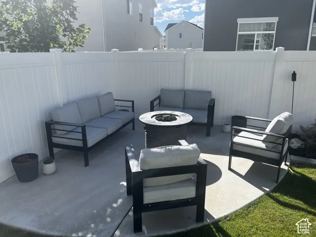 Private patio with concrete surfacing, enclosed by a white privacy fence