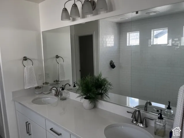 Dual vanity with undermount sinks, single-handle faucets, and a full-width mirror