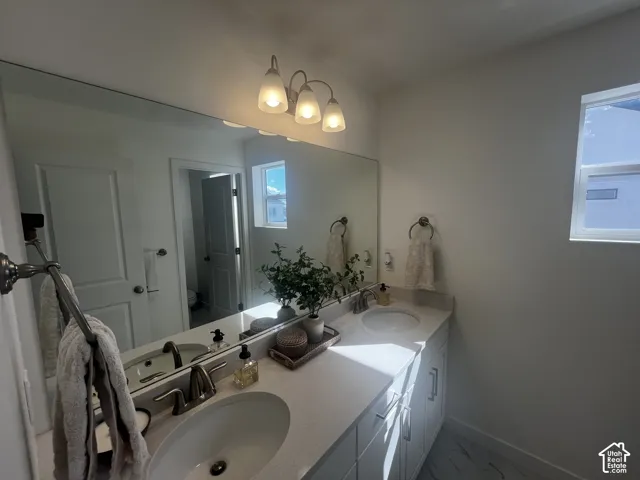 Dual vanity with undermount sinks, white countertop, and brushed nickel fixtures