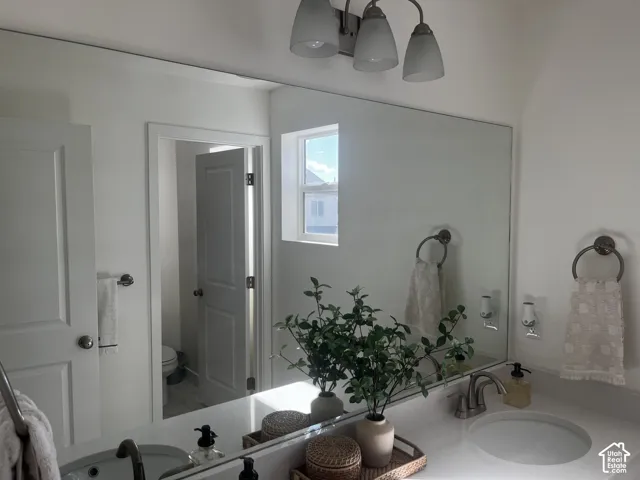 Bathroom vanity featuring a single basin, wall-mounted mirror, and brushed nickel fixtures