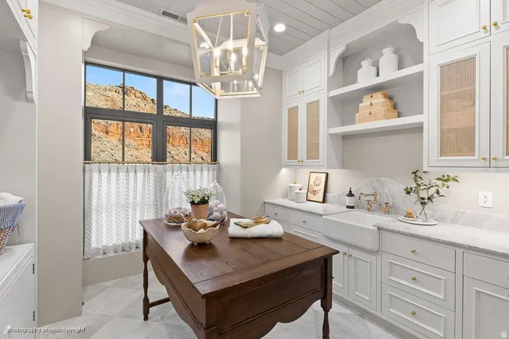 Refined home office featuring white shaker cabinetry with glass-front upper doors, quartz countertops, and polished hardware