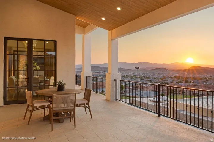 Expansive balcony featuring a tiled floor, wood-finish ceiling, and wrought iron railing