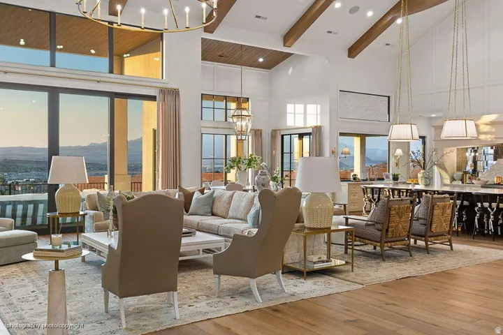 Expansive open-concept living space with vaulted ceilings featuring exposed wood beams