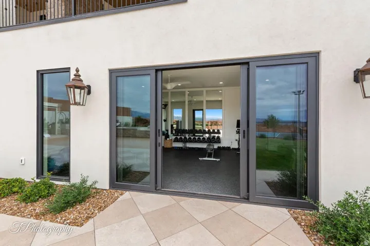 Sliding glass doors opening to a lower-level room with high ceilings and recessed lighting