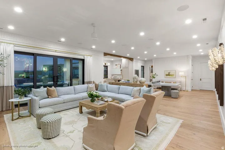 Expansive open-concept room with wood-finish flooring, recessed lighting, and a modern ceiling fan
