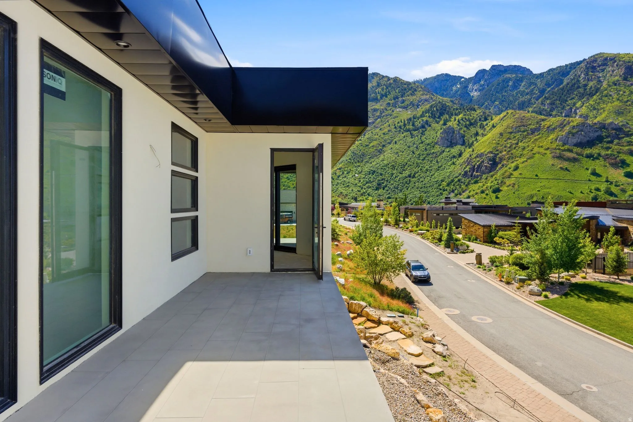 Expansive outdoor patio with large format tile flooring and a sleek black overhang