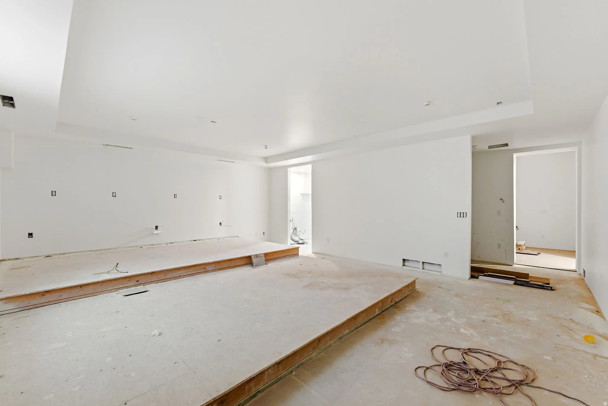 Spacious interior with white walls, recessed ceiling lighting, and a raised platform