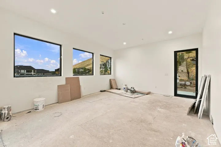 Interior space featuring recessed lighting, three large rectangular windows, and a full-height glass-paneled door