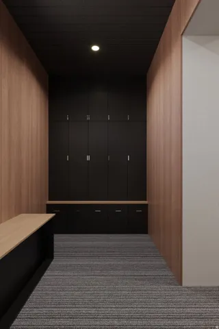 Wood-paneled walls, built-in black cabinetry with metal hardware, light wood-finish countertops, recessed lighting, and striped carpet flooring