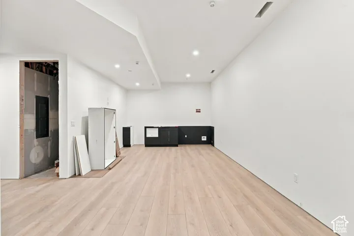 Neutral interior space featuring wood-finish flooring, recessed lighting, and built-in cabinetry