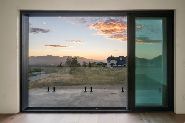 Expansive multi-panel sliding glass door with dark trim, leading to an outdoor balcony