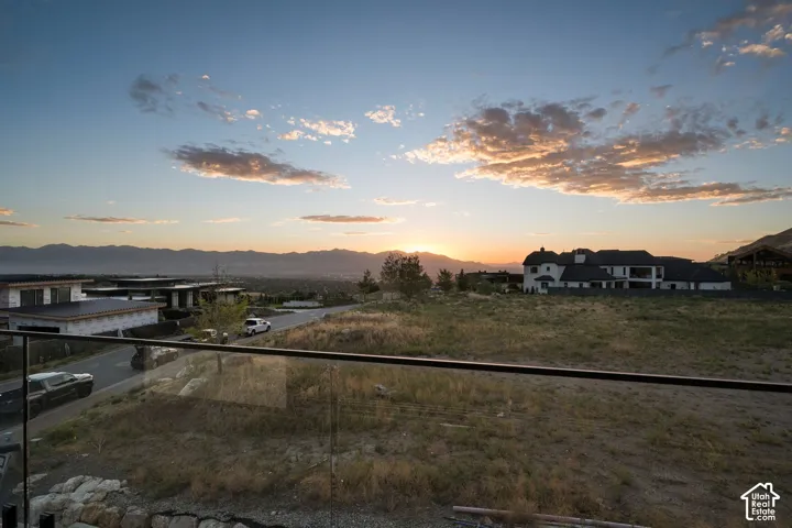 Panoramic mountain backdrop featuring a glass-panel railing with a metal handrail