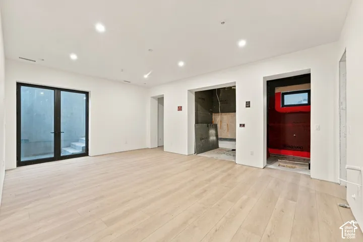 Interior space featuring wood-finish flooring, recessed lighting, and black-framed glass double doors