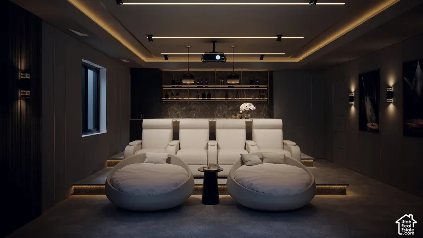 Dedicated media room featuring tiered seating, built-in shelving with integrated lighting, and a recessed ceiling with track lighting