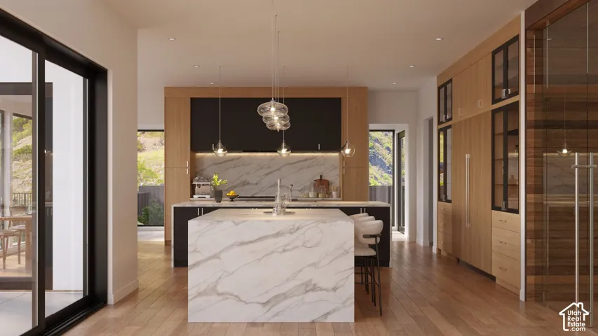 Spacious kitchen featuring a large waterfall island with integrated seating, stone backsplash, recessed lighting, and wood-finish flooring