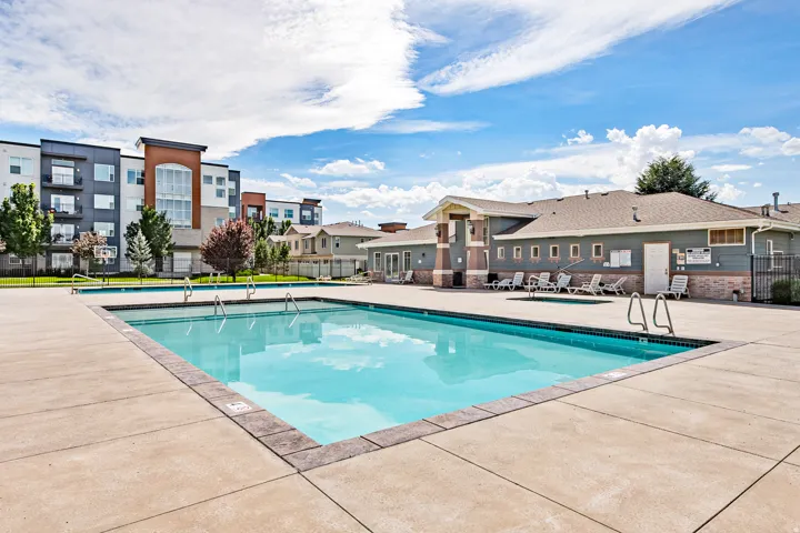 Expansive concrete pool deck with swimming pool and hot tubs